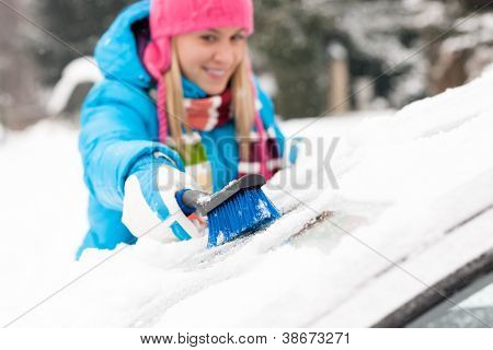 Woman wiping snow car window using brush winter happy work
