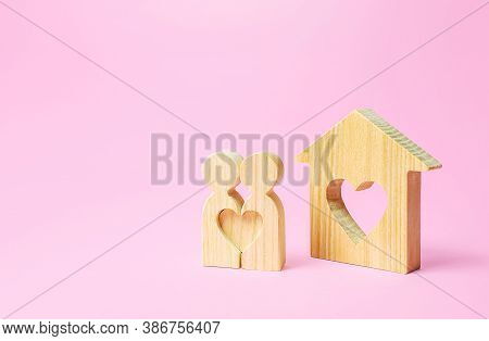 Figures Of A Love Couple Stand Near House With A Heart. Affordable Cheap Housing For Young Couples A