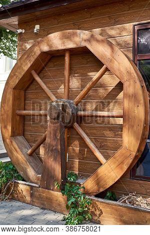 Decorative Sunlit Wooden Mill Wheel In A City Street