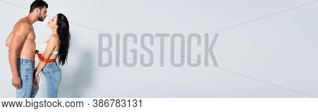 Panoramic Shot Of Muscular And Bearded Man Tying Sexy Woman In Bra On White