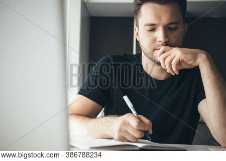Thoughtfull Caucasian Man Concentrated On Work Is Writing Something While Working From Home