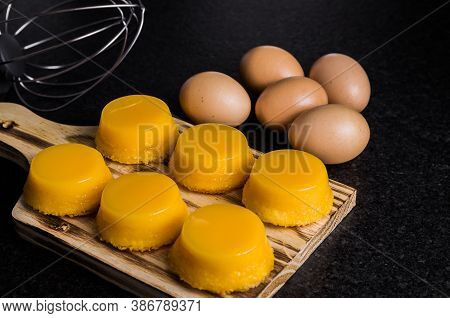 Delicious Quindins On Wooden Board, Traditional Brazilian Dessert Made With Egg Yolk, Sugar And Coco