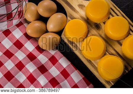Delicious Quindins On Wooden Board, Traditional Brazilian Dessert Made With Egg Yolk, Sugar And Coco