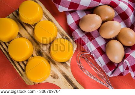 Delicious Quindins On Wooden Board, Traditional Brazilian Dessert Made With Egg Yolk, Sugar And Coco
