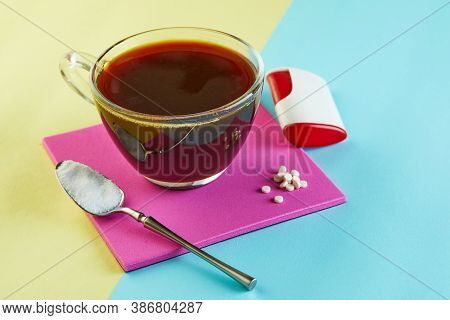 Cup Of Coffee And Pills Of Sugar Substitute And Natural Sweetener In Powder On A Purple Podium.