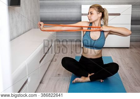 Woman At Home Trying To Lose Weight And Have Training With Elastic Band In Her Hands