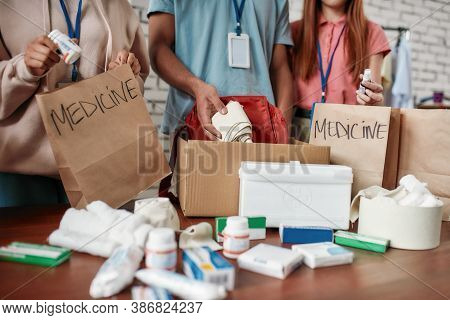 Cropped Shot Of Group Of Volunteers Packing Medicine Donation In Paper Bags And Boxes For Needy Peop