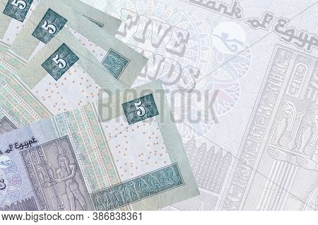 5 Egyptian Pounds Bills Lies In Stack On Background Of Big Semi-transparent Banknote. Abstract Busin