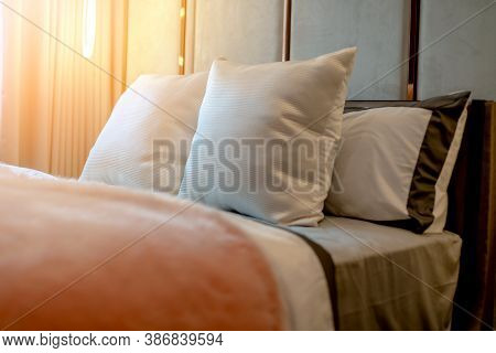 Bed Maid-up With Clean White Pillows And Bed Sheets In Beauty Bedroom. Close-up. Interior Background