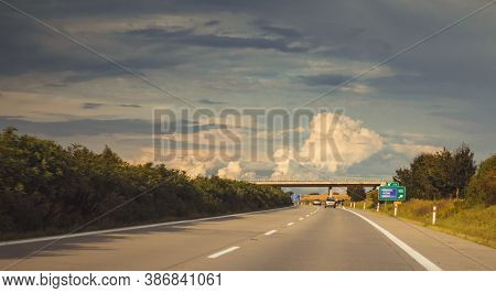 A Highway Leading To The Horizon, A Bridge In The Distance, In Nature, On A Background Of Blue Sky W