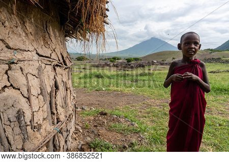 Engare Sero. Tanzania - January 2020: Indigenous Maasai Boy Near The Clay Hut In Traditional Village