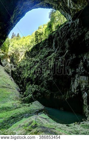 Macocha Gorge From The Bottom With The Small Lake And Steep Rocks