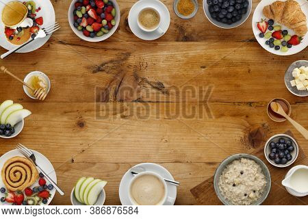 A Border Of Delicious Breakfast Plates, Pancakes And Pasteries, Bowls Of Fruit And Porridge, And Cup