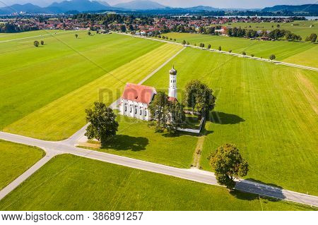 Aerial View Of Church Near Schwangau On Summer Day, Forggensee In Background