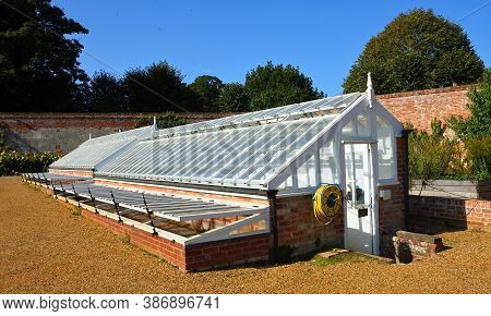 Aylsham, Norfolk, England - September  21, 2020:  Traditional Green Houses With Trees And Blue Sky I