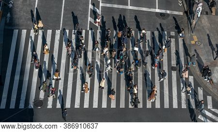 Elevated View Over Crowd Pedestrian Crossing In Road Intersection At Day