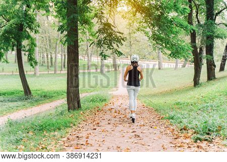 Young Beautiful Woman Riding An Electric Scooter In A City Park- Concept Of Sustainable Personal Mob