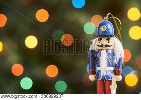 Traditional Colorful Wooden Christmas Nutcracker With A Green Background With Colored Lights Out Of 