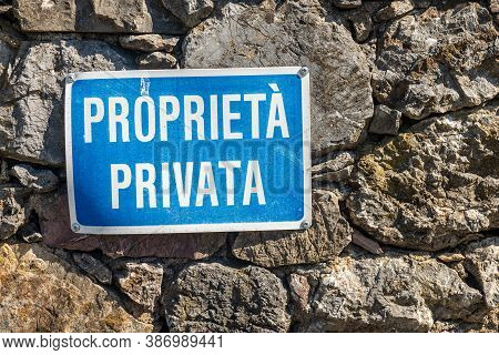 Proprieta Privata, Blue And White Private Property Sign In Italian Language Hanging On A Stone Wall.