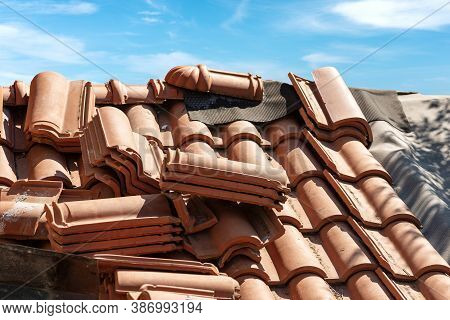 Closeup Of A Roof Under Repair With Terracotta Orange Tiles (coppo In Italian Language). Blue Sky Wi