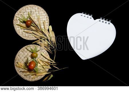 Mock-up Scene. Blank Heart-shaped Notebook, Dry Seeds, Straw Work And Rose Hips Isolated On Black Ba