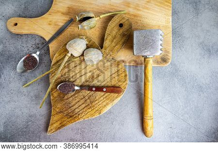 Poppy Seed Plant And Seed On Breadbord, Spoon And Dasher On Desk. Top View