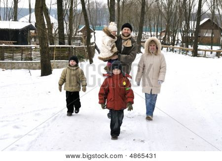 Paseo familiar feliz dar una vuelta juntos al aire libre en invierno