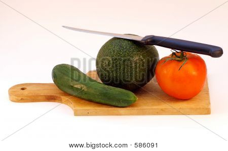 Gemüse und ein Messer auf einer Holzplatte