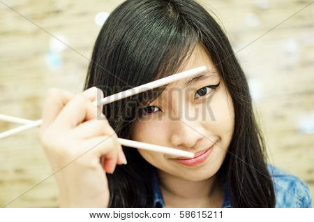 asian young woman holding chopsticks