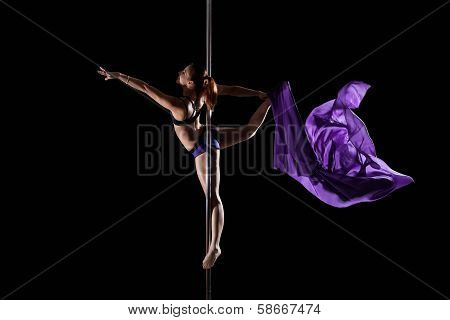 Smiling girl dancing on pilon with violet cloth