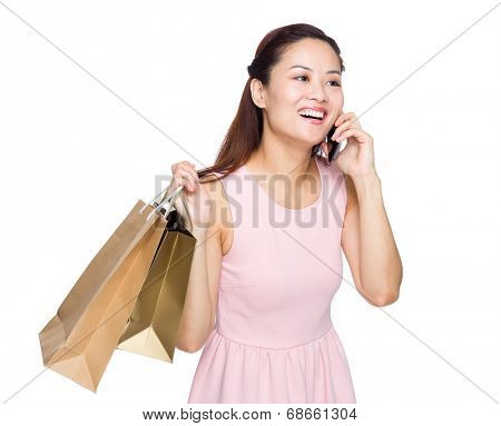 Asian woman shopping and talking on mobile phone isolated