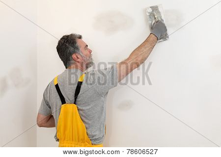 Worker Repairing Plaster At Wall