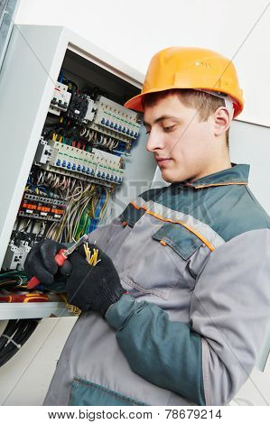 electrician builder engineer worker working with cable in fuse switch box