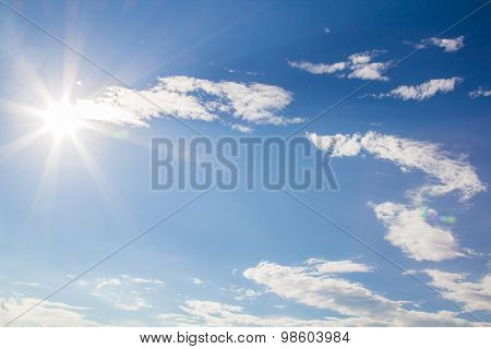 Natural Lens Flare And Radiating Rays In A Blue Sky With Clouds