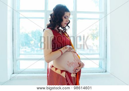 The pregnant woman belly with henna tattoo