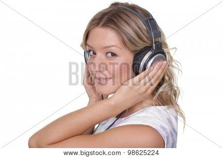 Happy young blonde woman listening to music, isolated on white