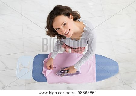 Woman Ironing Cloth On Ironing Board