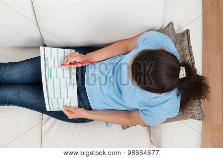 Woman On Sofa With Calendar And Pen