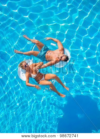 Couple Outside Relaxing In Swimming Pool in the summertime