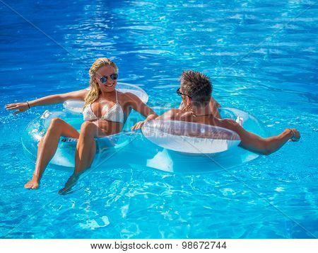 Couple Outside Relaxing In Swimming Pool in the summertime
