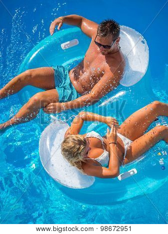 Couple Outside Relaxing In Swimming Pool in the summertime