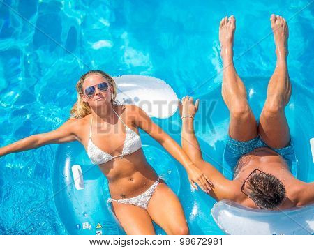 Couple Outside Relaxing In Swimming Pool in the summertime