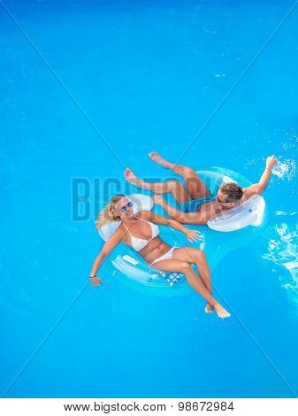 Couple Outside Relaxing In Swimming Pool in the summertime