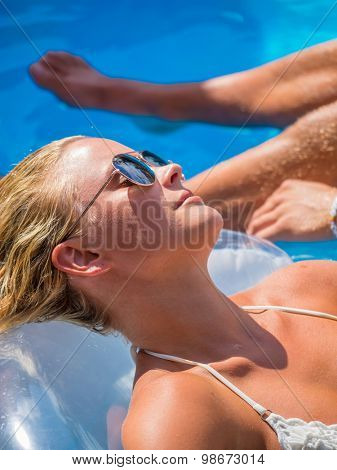 Couple Outside Relaxing In Swimming Pool in the summertime