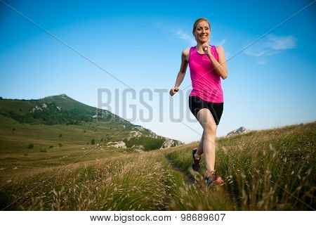 Beautiful Young Woman Runns Cross Country On A Mountian Path At Sunrise