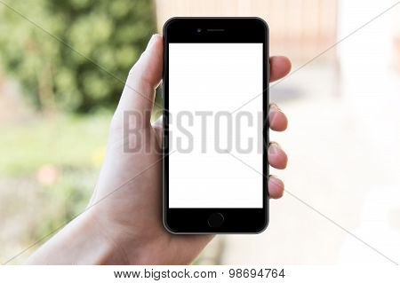 Man's hand shows mobile smartphone in horizontal position, blurred background