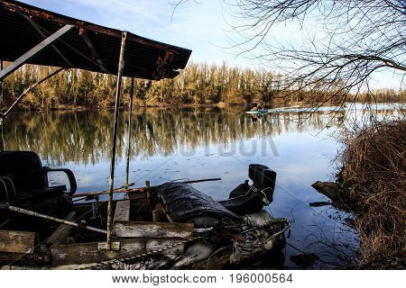 river between germany and france // with an selfmade rustic boat in front and two fishermen in the background