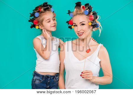 Funny family Mother and her child daughter girl with a paper accessories. Beauty funny girl holding paper lips on stick. Beautiful young woman holding paper lips on stick.