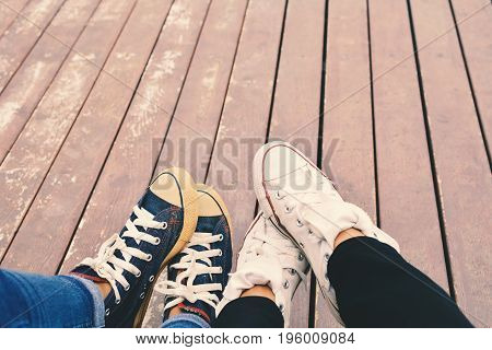 Feet of lover on old wooden background color of hipster tone concept affection