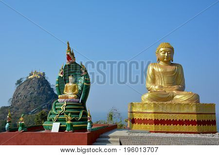 Beautiful view of the golden Buddha statue with Mount Popa on the background. Situated in southeast of Bagan Myanmar (Burma).